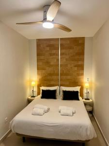 a bedroom with a large bed with a ceiling fan at BARAKA Suite BANUS in Marbella +23 photos