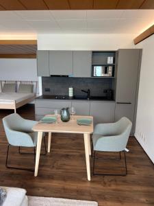 a kitchen with a wooden table and two chairs at Apartment 18 am Brienzersee in Brienz