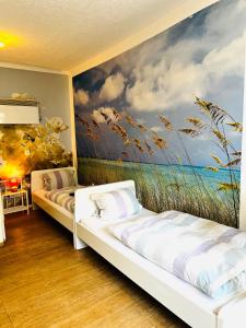 two beds in a room with a painting on the wall at Ferienwohnung in Ediger Eller in Ediger-Eller