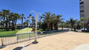 a street light with a fence and palm trees at BEACH VALENCIA LUXURY D15-21 Apartment with terrace and sea views with two rooms in Valencia