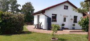 a white house with a table in the yard at Kleines Ferienhaus Heyne in Rerik