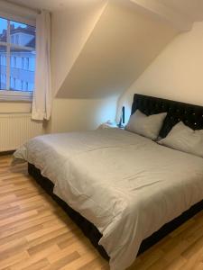 a large bed in a bedroom with a window at Charmante 3-Zimmer Wohnung in Burg bei Magdeburg