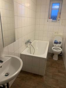 a bathroom with a tub and a toilet and a sink at Charmante 3-Zimmer Wohnung in Burg bei Magdeburg