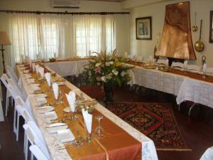 una mesa larga en una habitación con sillas blancas en 12 FLEETWOOD en Harare