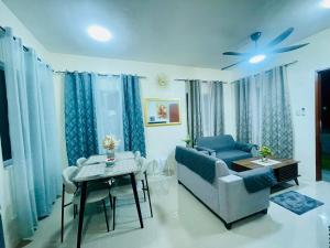 a living room with a blue couch and a table at Staycation House in Dauis in Dauis