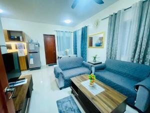 a living room with a blue couch and a table at Staycation House in Dauis in Dauis +5 photos