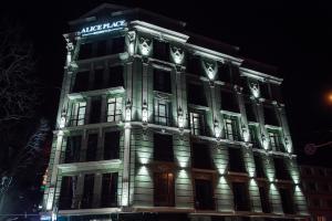a large building with lights on it at night at Alice Place Hotel in Odesa