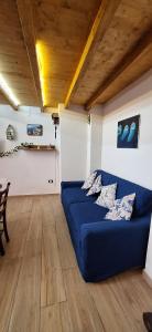 a blue couch in a living room with a wooden ceiling at La casa del Maestro - Gallipoli - centro storico in Gallipoli