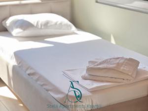 a white bed with two slices of cake on it at Stela Apartments in Ksamil