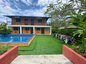 a house with a yard with a swimming pool at The SeaShell Chalet Melaka Kuala Sg Baru in Kampung Kuala Linggi