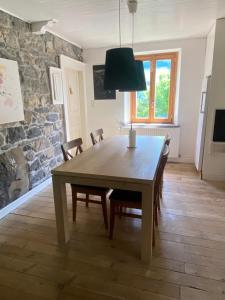 Un comedor con mesa y sillas de madera. en Logement individuel 3 pièces dans chalet, en Glières-Val-de-Borne 20 fotos más