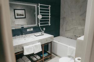 a bathroom with a sink and a large mirror at Alice Place Hotel in Odesa +61 photos
