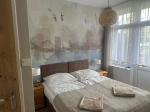 a bedroom with a bed with two pillows on it at KAMERALNY przy promenadzie - domki, apartamenty, pokoje in Charzykowy