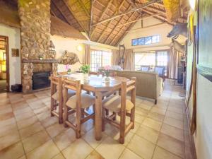 a dining room with a table and a fireplace at Mabalingwe Mistykie Lodge in Warmbaths