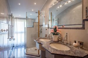 un bagno con due lavandini e una doccia di Villa Casa Gemelli a Capolona