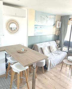 a living room with a table and a bed at Cap Coudalère entre lac et mer in Le Barcarès