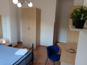 a room with a bed and a table and a blue chair at Il Maestrale B&B in Castellabate +32 photos