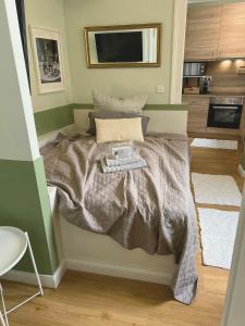 a bedroom with a bed with a gray comforter at Bar'n'Bed in der schönen Koblenzer Altstadt in Koblenz +1 photo