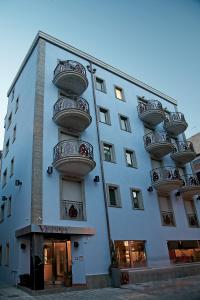 a white building with balconies on the side of it at Victoria Hotel in Pescara