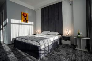 a bedroom with a large bed and two tables at Hotel Cristal in Mamaia Sat/Năvodari +100 photos