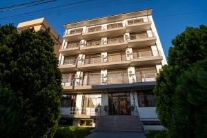 an apartment building with a staircase in front of it at Hotel Cristal in Mamaia Sat/Năvodari