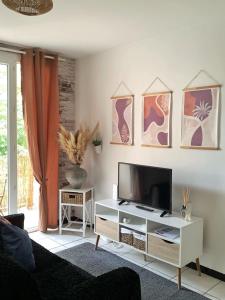 ベジエにあるLe Petit Provençalの白いキャビネットの上にテレビが置かれたリビングルーム