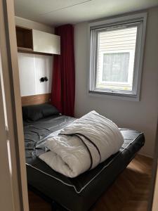 GastesにあるMobil-home 3 chambres, mh 459の窓のある小さな部屋のベッド