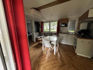 GastesにあるMobil-home 3 chambres, mh 459の部屋にテーブルと椅子のあるキッチン