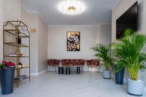 a lobby with a table and chairs and plants at Hotel Cristal in Mamaia Sat/Năvodari