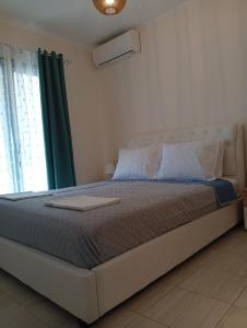 a bed in a bedroom with a green curtain at LV apartment-in the heart of Parga in Parga +28 photos