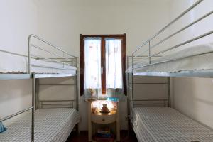 a small room with two bunk beds and a window at Villetta con terrazza a 400 mt dal mare in Geremèas
