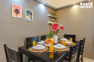 a dining room with a table and chairs with fruit on it at Belas Palmeiras by VEO - Part of StayVista with Pool & Bonfire in Alibaug