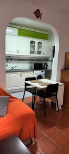 a living room with a table and a kitchen at Ana Mónica Pereira in Vila Nova de Milfontes