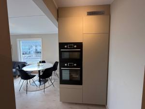 a kitchen with a stove and a table with chairs at Moderne hus i sentrum av Lillestrøm in Lillestrøm