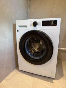 a white washing machine sitting in a room at Moderne hus i sentrum av Lillestrøm in Lillestrøm