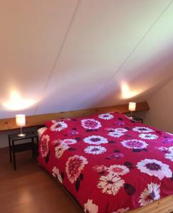 a bedroom with a red bed with flowers on it at 't Veldhuisje in Kootwijkerbroek