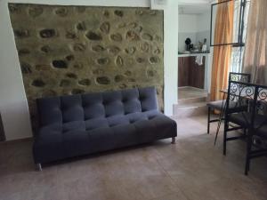a couch in a living room with a stone wall at Central Campestre Apartment in Popayan