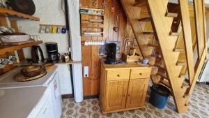 a small kitchen with a stove and a staircase at Appt Copropriété SucBlanc 211 Impasse des Taoures Molines en Queyras in Molines-en-Queyras +12 photos