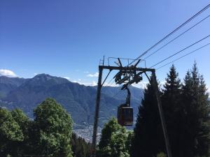 a ski lift in the mountains with trees and mountains at Ca' Negra, Do-Minus Design Retreat & SPA in Bellinzona