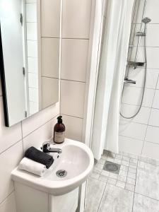 a white bathroom with a sink and a shower at Fjällbacka Bed And Breakfast in Fjällbacka +30 photos