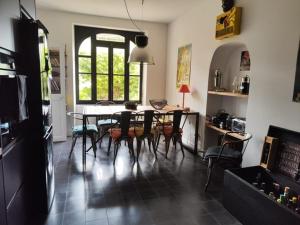 a kitchen with a table and chairs in a room at Bastide du château in Montfaucon