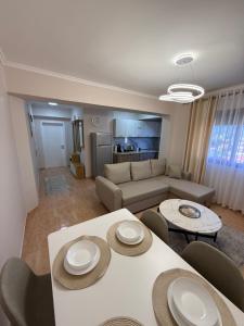 a living room with a couch and a table and chairs at Emidio Apartment in Shkodër