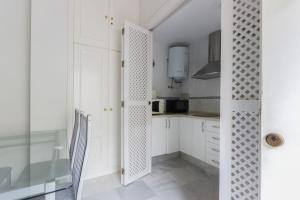 a kitchen with white cabinets and a glass door at Ribera del río - Centro in El Puerto de Santa María