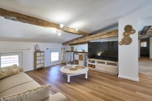 a living room with a couch and a tv at Charme, confort en centre-ville in Limoux