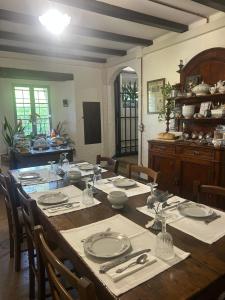 a dining room with a long table with plates and glasses at A 5 min dalla Rocchetta Mattei - B&B Antico Mulino in Camugnano