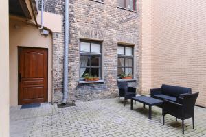 un patio avec des chaises et une table et un bâtiment dans l'établissement Cosy and authentic apartment in Vilnius Old Town, à Vilnius