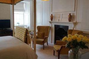 a living room with a bed and a fireplace at Bishopsgate House Hotel in Beaumaris