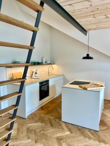 a kitchen with white cabinets and a staircase at Loft über Berchtesgaden in Berchtesgaden
