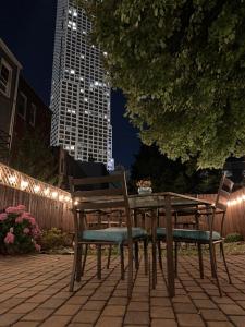 a wooden table and chairs sitting on a patio at night at Magnolia Stay near New York City in Jersey City