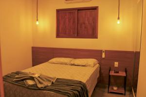 Un dormitorio con una cama y una ventana en la pared. en Chalés Gostoso - Anfitrya, en São Miguel do Gostoso 10 fotos más